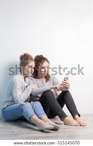 Young happy teenage girls using their phones