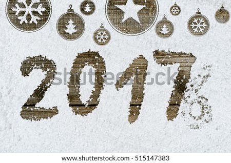 christmas card or new year background made of xmas symbols handwritten on snow and wooden table