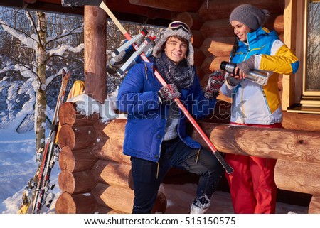 Young man with ice hockey skates and stick at winter cottage.