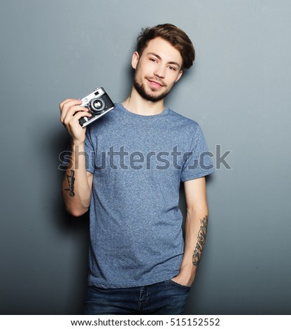Hipster fashion photographer man holding retro camera