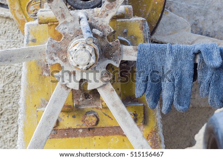 pair of gloves on the cement mixer in the construction site, horizontal photo