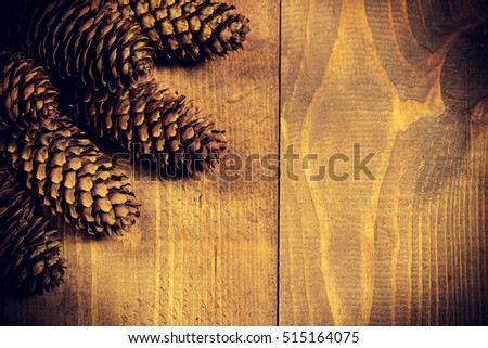 Christmas background with pine cones on wooden surface. Copy space. 