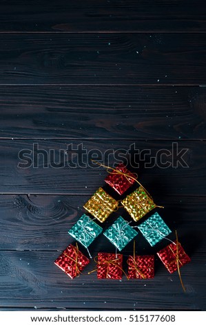 Christmas tree made of colorful box on a black background. Space for text