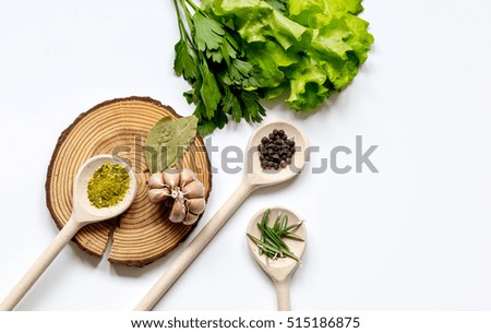 various spices in spoon with wooden stand on white background