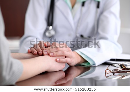 Friendly female doctor hands holding patient hand sitting at the desk for encouragement, empathy, cheering and support while medical examination. Bad news lessening, medicine and health care concept  Royalty-Free Stock Photo #515200255