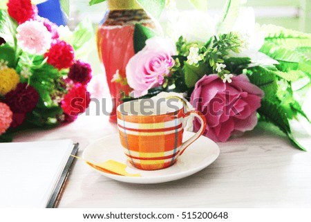 Fresh roses with diary and cup of coffee