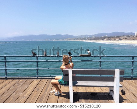 Blonde girl taking photos on Santa Monica Pier