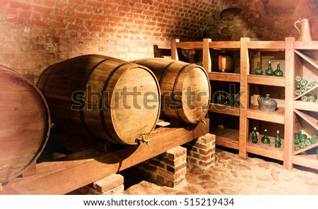Beautiful photo of barrels with a wine in a cellar with a brick wall background. Wonderful vintage