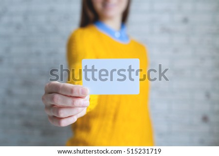 Attractive young smiling girl holding blank business card