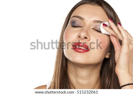 young woman removal her make-up with a piece of cotton Royalty-Free Stock Photo #515232061