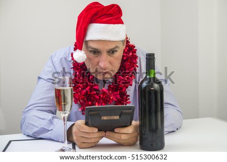 Business Man Celebrate Merry Christmas And Happy New Year Wear Santa Hat. Feeling sick and tired. Frustrated young man keeping eyes closed while sitting at his working place in office