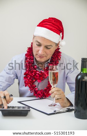 Portrait Of A Businessman Calculating Finance In Office. Business Man Celebrate Merry Christmas And Happy New Year Wear Santa Hat