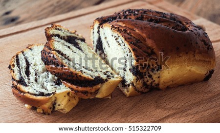 poppy seed Roll on a wooden surface, closeup