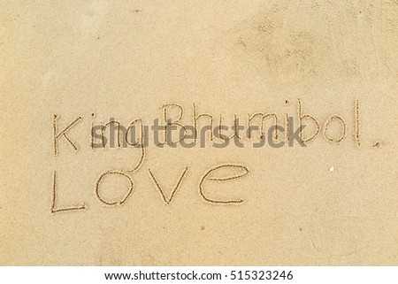 written words "King Bhumibol Love" on sand of beach