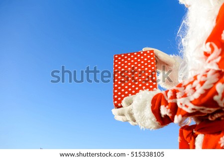 Santa Claus delivering Christmas presents on light background outdoors background. Happy Xmas festive winter time, closeup image