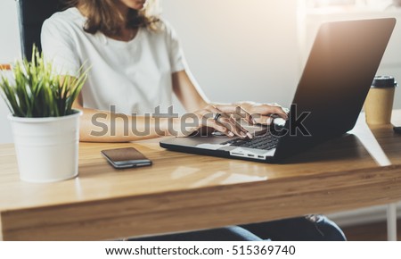 Cropped image of professional businesswoman working at her office via laptop, young female manager using portable computer device while sitting at modern loft, flare light, work process concept Royalty-Free Stock Photo #515369740