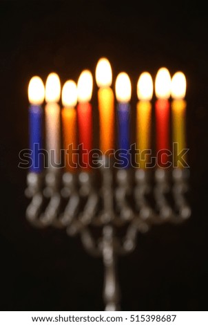abstract and blurry image of jewish holiday Hanukkah background with menorah (traditional candelabra) and burning candles