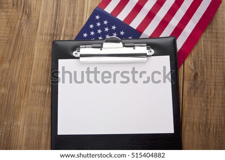 blank clip board and USA flag on wooden background