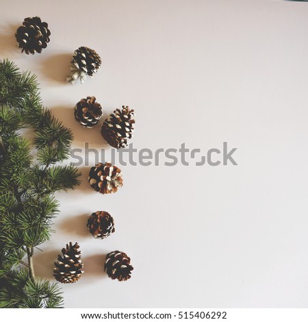 Flat lay of Christmas decorated pincones on white background - Trendy minimal flat lay design