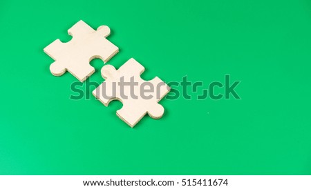 Few pieces of blank wooden puzzle. Isolated on green background. Slightly de-focused and close-up shot. Copy space.