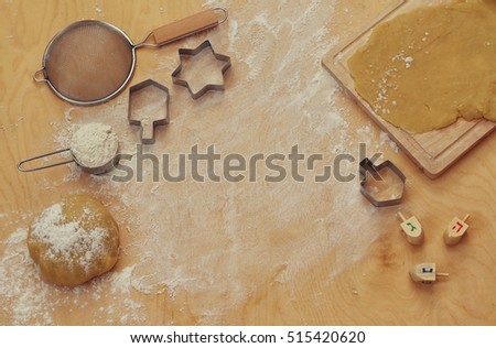top view image of jewish holiday Hanukkah concept. Baking donuts and cookies on wooden kitchen table

