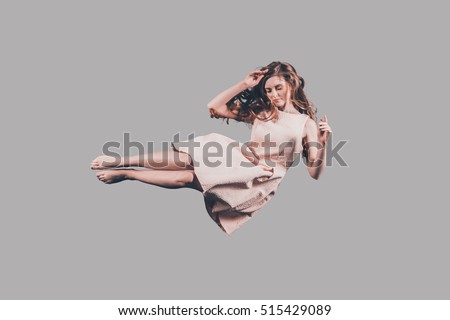 Beauty in air. Studio shot of attractive young woman hovering in air