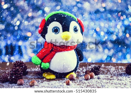 Snow Falling On Cute Happy Penguin Christmas Toy Smiling On Snowy Wooden Background. Selective Focus. Vintage Filter Applied.