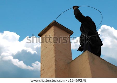 Chimney sweeper on the roof of a house in an attempt of chimney sweeping Royalty-Free Stock Photo #515459278