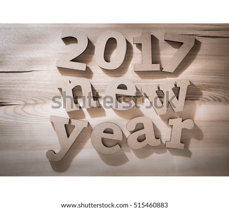 The greeting message "2017 new year" composed volumetric letters on wooden background.