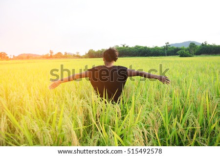 happy woman stand at rice field with sunlight. soft focus