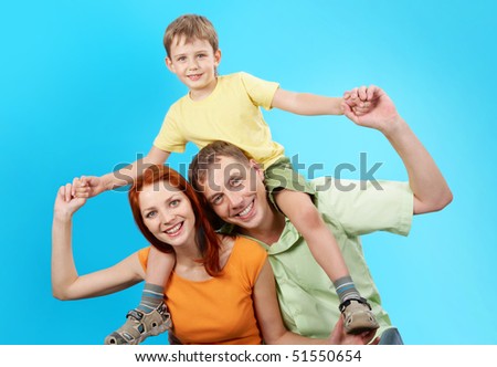 Image of mom and dad with their kid on the shoulders