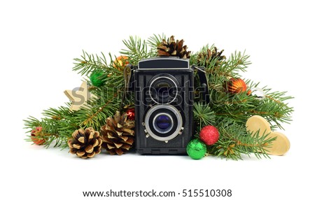 Old camera and tree branches with ornaments. Christmas time. Memories. Festive decorations. Isolation on a white background. Retro technology and the present