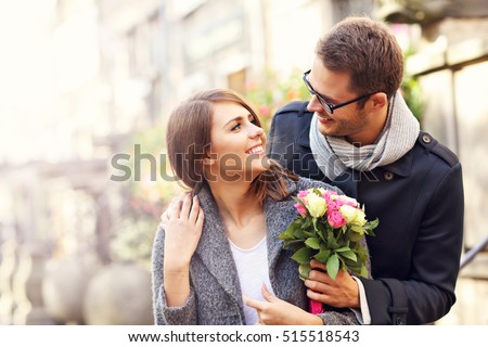 Picture showing young couple with flowers dating in the city