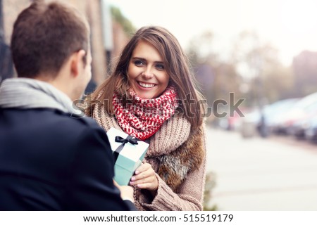 Picture showing young couple with present in the park
