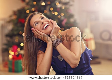 Picture showing happy woman sitting over Christmas tree