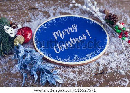 Merry Christmas Written In Chalk On Blue Chalkboard Holiday Background With Snow And Decorations.