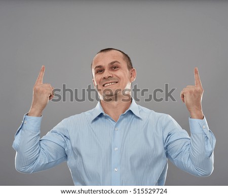 Happy businessman pointing up to copyspace