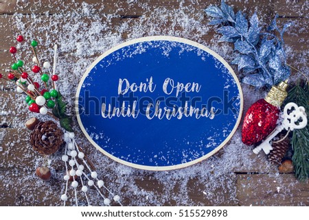 Don't Open Until Christmas Written In Chalk On Blue Chalkboard Holiday Sign Background With Snow And Decorations. Top View.