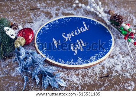 A Special Gift Written In Chalk On Blue Chalkboard Holiday Sign Background With Snow And Decorations.