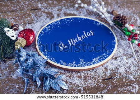 St. Nicholas Written In Chalk On Blue Chalkboard Holiday Sign Background With Snow And Decorations.