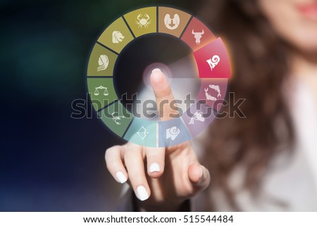 Zodiac signs on touch screen. Woman choosing Aries horoscope symbol.