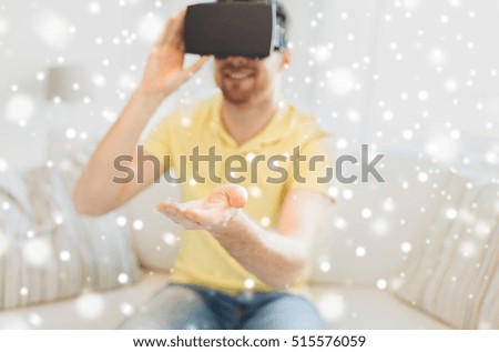 technology, augmented reality, gaming, entertainment and people concept - close up of young man with virtual headset or 3d glasses playing videogame at home over snow