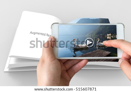 Augmented reality marketing concept. Hand holding smart phone use AR application to play video for customer. Royalty-Free Stock Photo #515607871
