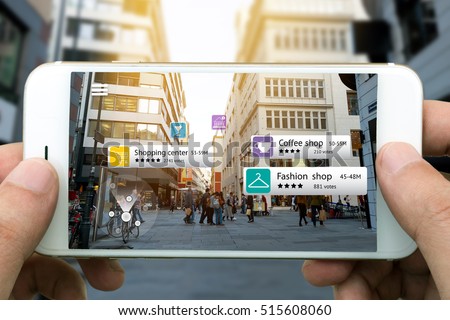 Augmented reality marketing concept. Hand holding smart phone use AR application to check relevant information about the spaces around customer. City and flare light background Royalty-Free Stock Photo #515608060