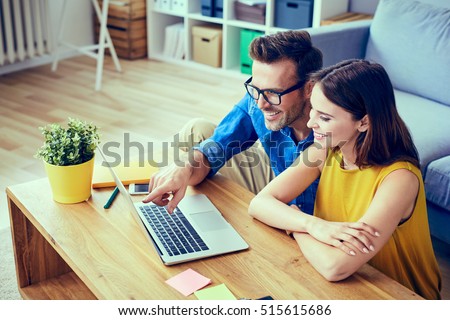 Happy couple with laptop spending time together at home  Royalty-Free Stock Photo #515615686