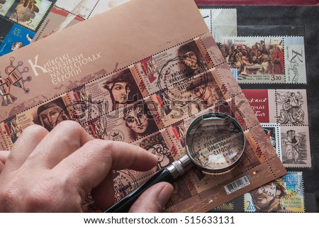 Still life with stamps in an album and magnifying glass. Ukrainian stamps Royalty-Free Stock Photo #515633131