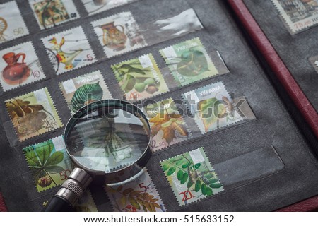 Still life with stamps in an album and magnifying glass. Ukrainian stamps Royalty-Free Stock Photo #515633152