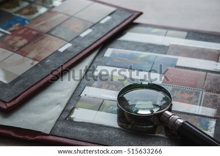 Still life with stamps in an album and magnifying glass. Ukrainian stamps Royalty-Free Stock Photo #515633266