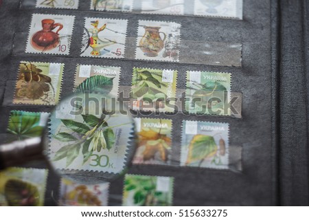 Still life with stamps in an album and magnifying glass. Ukrainian stamps Royalty-Free Stock Photo #515633275