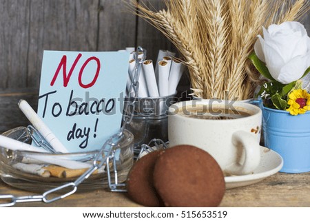 breakfast cup of coffee and cookies, a pack of cigarettes shut down by chain. World No Tobacco (smoking) Day infocard. dark filter